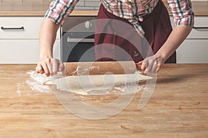 Female baker hands cooking pastry with rustic rolling