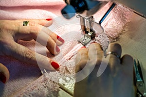 Female Hands Sewing Fringe on Pink Garment