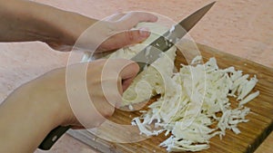 Female hands shred cabbage. Home kitchen.