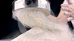 Female hands sifting flour