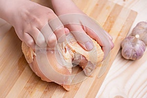 Female hands skinning chicken breast