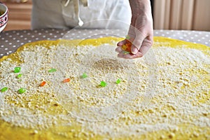 Female hands sprinkle flour on the dough