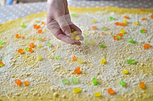 Female hands sprinkle flour on the dough