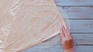 Female hands stack linen napkins of different colours on a wooden old table.