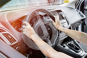 Female hands with steering wheel close up. Woman driving car and holding tight car steering wheel