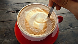 Female Hands Stirring Coffee in Red Cup