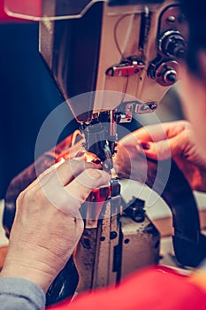 Female hands stitching a part of the shoe  in the handmade footwear industry