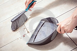 Female Hands Sweeping Dust With A Broom On A Dustpan, Housekeeping Concept