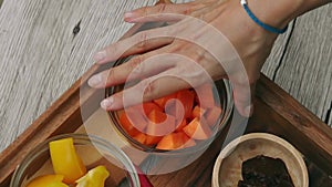 Female hands taking cut carrot cubes from tray. Vegan and vegeterian food. Lifestyle of health and sustainability