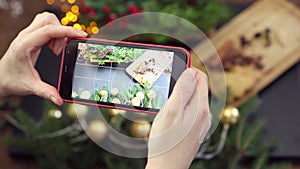 female hands taking photo christmas decorations table using smartphone camera