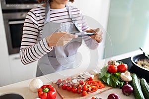 Female hands taking photo of fresh organic vegetables, cropped