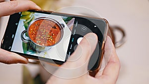 Female Hands Taking a Photo on a Smartphone Traditional Ukrainian Red Borscht