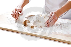 Female hands taking rolling pin for making dough on board