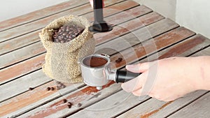 Female hands tamping coffee in a portafilter for espresso