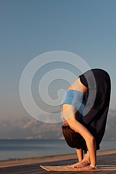 Female hands touching mat, woman practicing yoga uttanasana