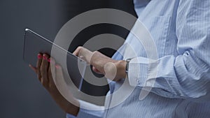 Female hands touching pad screen outdoors closeup. Businesswoman work remotely.