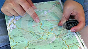 Female hands with travel map and compass