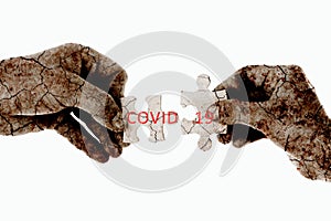 Female hands two puzzles with a texture overlay of dried earth and the text in English coovid -19 on a white background