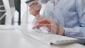 Female hands typing credit card number on computer keyboard. Woman making online purchase. Online payment service.