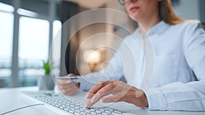 Female hands typing credit card number on computer keyboard. Woman making online purchase. Online payment service.