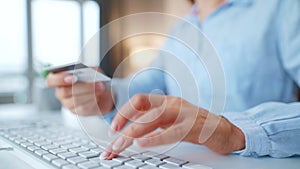 Female hands typing credit card number on computer keyboard. Woman making online purchase. Online payment service.