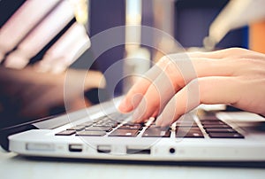 Female hands typing on keyboard of laptop