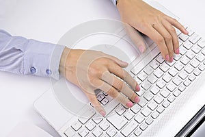 Female hands typing on keyboard, white computer