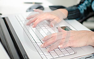 Female hands typing on a laptop computer keyboard