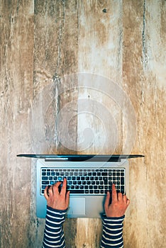 Female hands typing laptop computer keyboard, top view