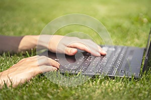 Female Hands are typing on the laptop keyboard.