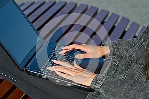 Female hands typing laptop keyboard close up