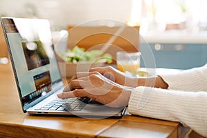 Female hands typing on laptop keyboard closeup
