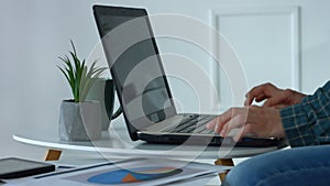 Female hands typing on laptop keyboard in home office