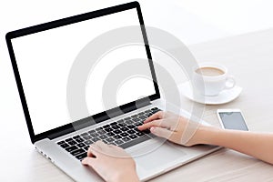 Female hands typing on a laptop keyboard with screen in