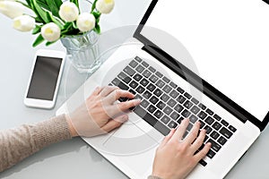 Female hands typing laptop keyboard with screen on tabl