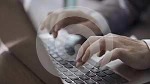 Female hands typing on laptop keyboard. Super close up of businesswoman`s hands working computer, woman in suit sits at