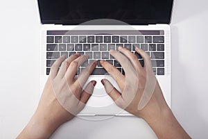 Female hands typing on a laptop keyboard. White background.