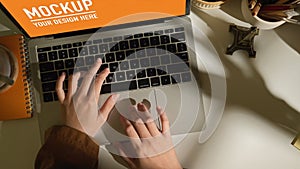Female hands typing on laptop keyboard on white worktable
