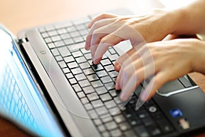 Female hands typing on a laptop pc keyboard