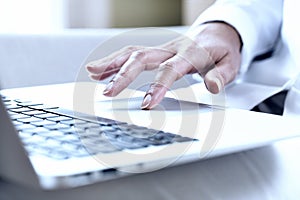 Female hands typing on a laptop trackpad