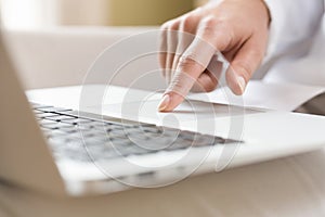 Female hands typing on a laptop trackpad