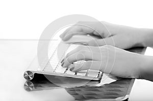 Female hands typing on white computer keyboard
