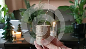 Female hands unwind a skein of twine. Pull the thread. For handmade decoration to the Christmas holidays.