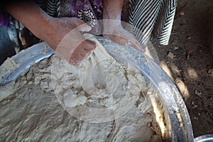 Female hands using flour in baking dough to make bread