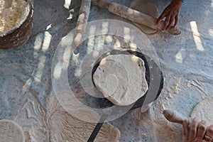 Female hands using flour in baking dough to make bread