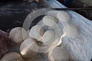 Female hands using flour in baking dough to make bread