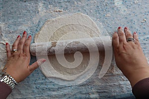 Female hands using flour in baking dough to make bread
