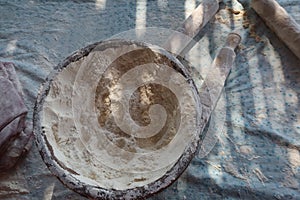 Female hands using flour in baking dough to make bread
