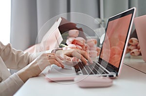 Female hands using laptop. Female office desk workspace homeoffice mock up with laptop, pink tulip flowers bouquet, smartphone and