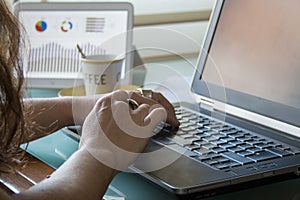 Female hands using laptop and tablet on home office desktop